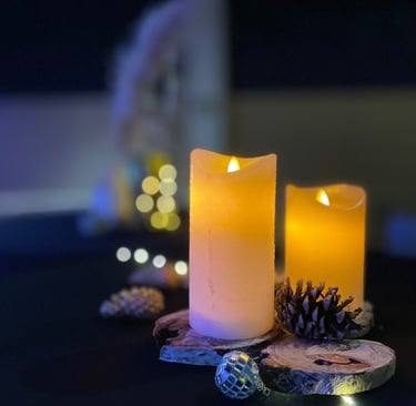 Détail de décoration de mange-debout avec bougies LED effet cire, rondins de bois, pommes de pin, bo