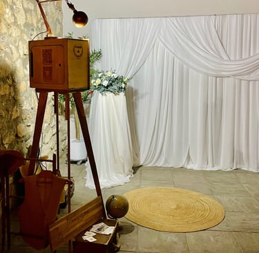 Photobooth en bois vintage installé lors d’un mariage, intégré dans une scénographie élégante avec r