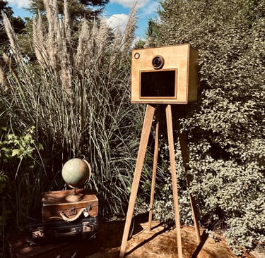 Photobooth en bois vintage installé en extérieur, sur trépied en chêne, intégré dans une scénographi