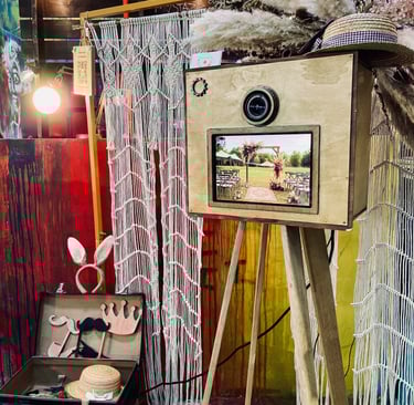 Photobooth en bois vintage installé lors d’un événement, avec écran actif et accessoires, intégré da