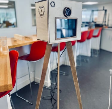 Photobooth en bois vintage avec écran intégré et objectif photo, fabrication artisanale sur trépied