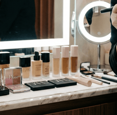 Maquiador profissional preparando a pele da cliente na bancada do We Hall Beauty.