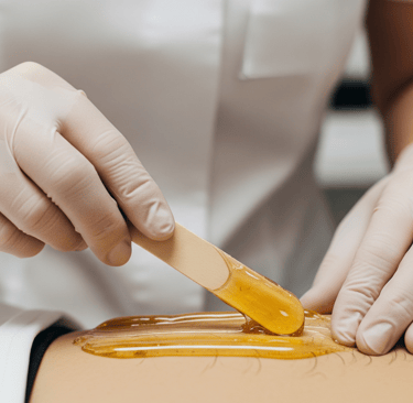 Profissional aplicando cera para depilação íntima em ambiente discreto no We Hall Beauty em Bauru.