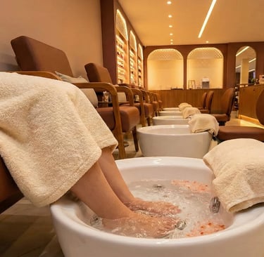 Ambiente de pedicure luxuoso com escalda-pés preparado para o protocolo de relaxamento no We Hall Beauty.