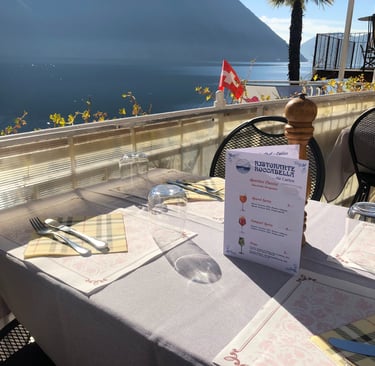 Tavolo apparecchiato con menù del Risotrante Roccabella sulla terrazza sul lago di lugano