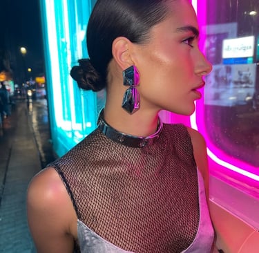 Cyberpunk Halloween style with chrome statement earrings and silver torque choker under neon lights