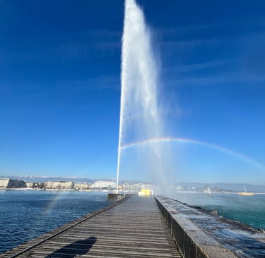 View of the Jet d'Eau forming a rainbow over a pier in Geneva, Switzerland