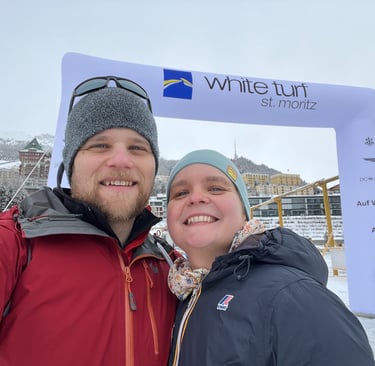 Colin and Corinne from Hidden Switzerland Travel in front of the entrance to the White Turf Horse Races in St. Moritz