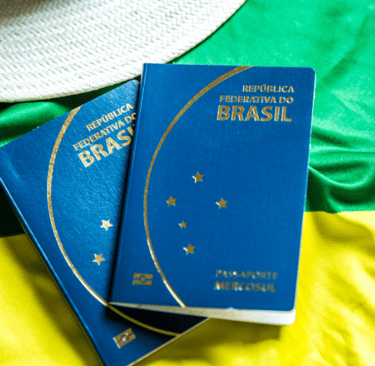 dois passaportes brasileiros en frente de uma bandera brasileira