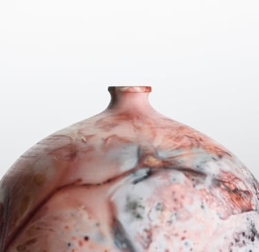 Handmade pit-fired ceramic vase with a unique marbled red and grey smoky finish on a white background.
