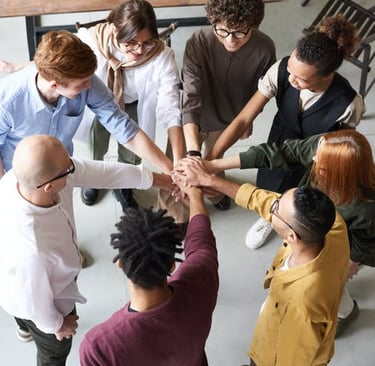 a group of people holding hands in a circle at AA meeting