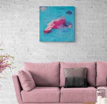 Blue and pink painting on white brick wall above pink sofa