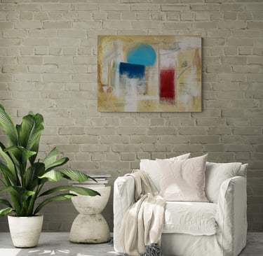 Tan painting with a cerulean sphere on brick wall above white lounge chair.