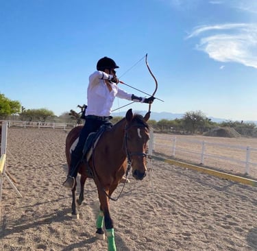 arqueria ecuestre Mexico. a man riding a horse and shooting arrows to a target