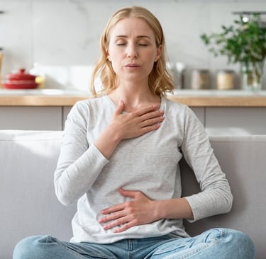 Woman sitting calmly with hands on chest and stomach, representing stress, hormone imbalance