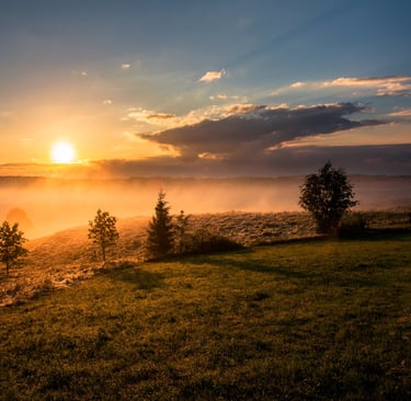 sunrise from hilltop overlooking a misty valley