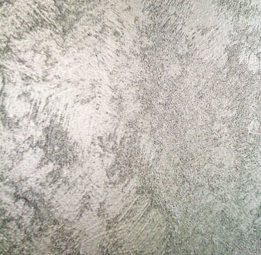 A cool silver paint sample showing off its shimmering grainy texture.