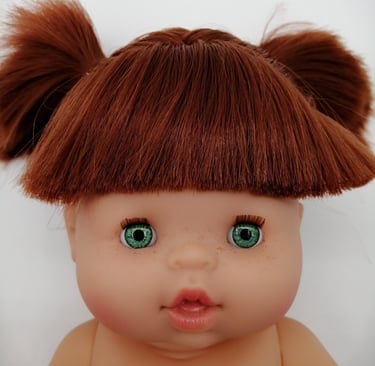 a Minikane baby doll with red hair and green eyes