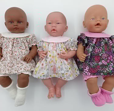 three dolls dolls dressed in dresses with round collar