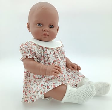 Minikane doll in cream floral dress with cream collar