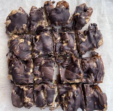 Close-up of no-bake date squares made with dates, nut butter covered with chocolate