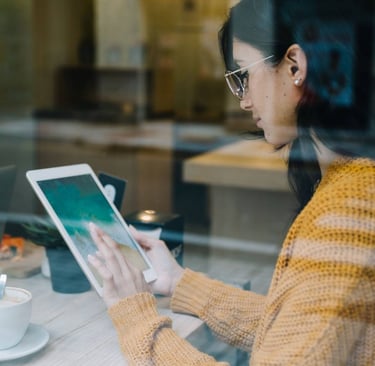 girl with tab and coffee on table