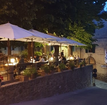 a restaurant with tables and umbrellas on a sidewalk