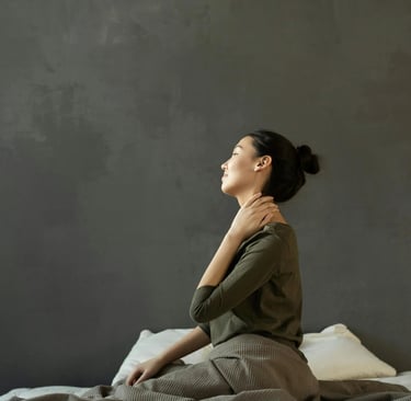 a woman sitting on a bed with a blanket on it