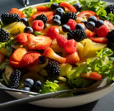 a bowl of fruit salad with berries and berries