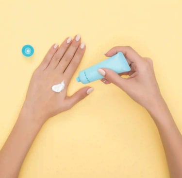 a woman's hands holding a tube of cream
