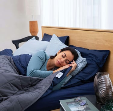 a woman is sleeping in a bed with a phone