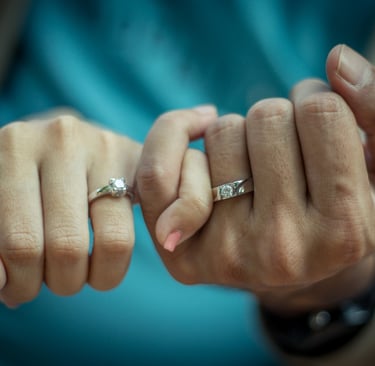 two hands of a couple with engagement rings