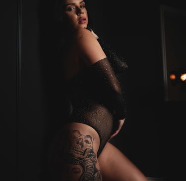 a woman in a black bodysuit and stockings with tattoos on her butt