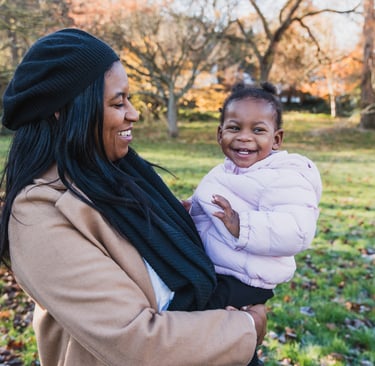 a woman holding her daughter in her arms in an autumn settings in Bexley