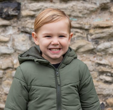 boy smiling towards the camera in a park in Bexley