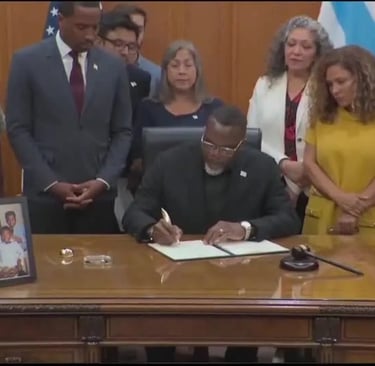 a man in a suit and tie is signing a document