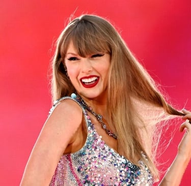 Taylor Swift sorrindo, com um vestido brilhante e puxando o cabelo, em um show.