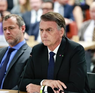 air Bolsonaro sentado em uma mesa, com outros participantes de uma reunião.
