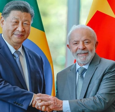 Xi Jinping e Lula apertam as mãos na frente das bandeiras do Brasil e China.