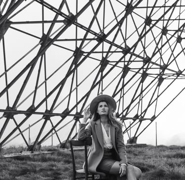 a woman sitting on a chair in a field