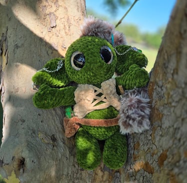 Handmade green goblin plushie with faux fur accents, leather-style vest, and chain accessories, pose