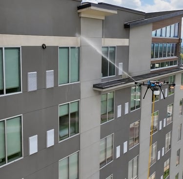 Drone pressure washing a large building