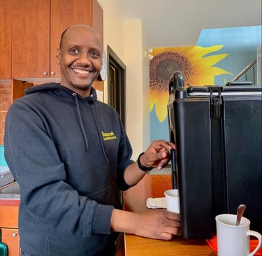 a man in a black jacket and a coffee mug at capital city mission