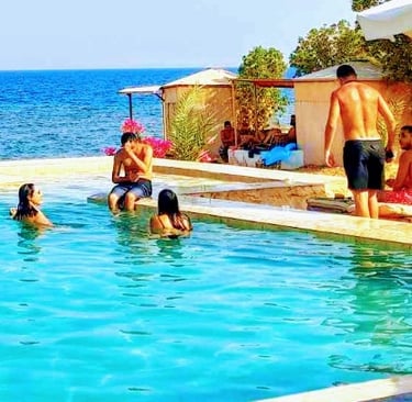 People in pool in front of the sea