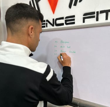 El entrenador anotando en la pizarra los ejercicios
