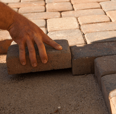 a person is placing bricks on a brick wall