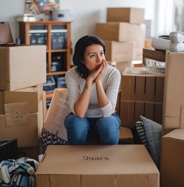 sad woman sitting surrounded by boxes
