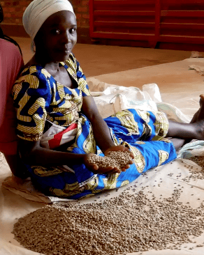 a woman sitting on a bed with a pile of coffeeseeds