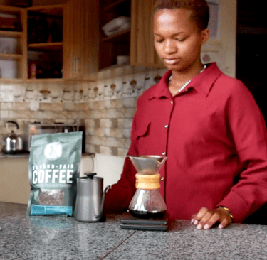 a woman in a red shirt is holding a coffee pot
