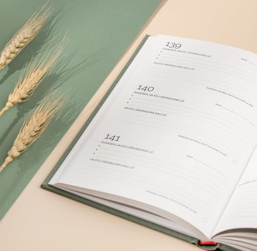 Atverstas dėkingumo žurnalas kasdieniams įrašams, šalia padėtų kviečių varpų.